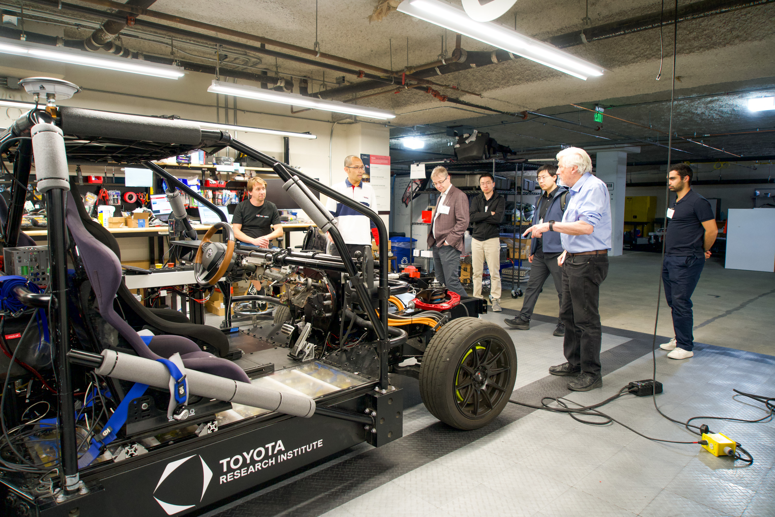 Scientists stand around a car model